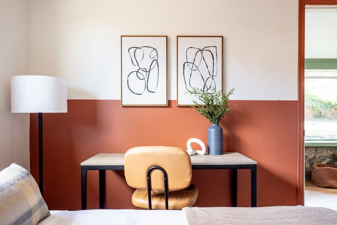 Bedroom workspace with terracotta lower wall band and white upper wall