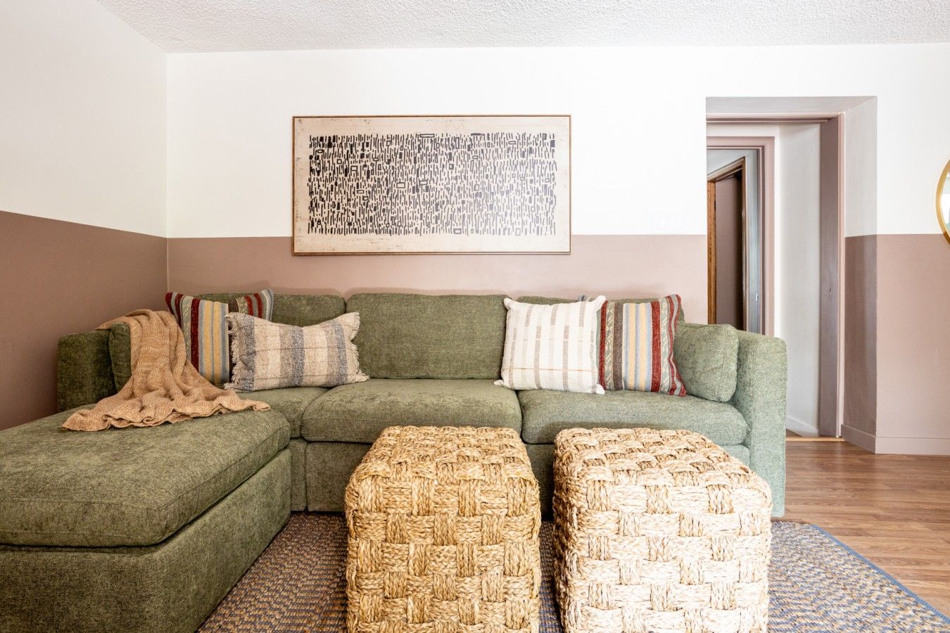 Living room with blush two-tone walls and green sofa
