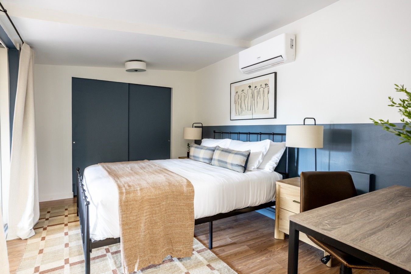 Bedroom with deep blue accent wall and white trim