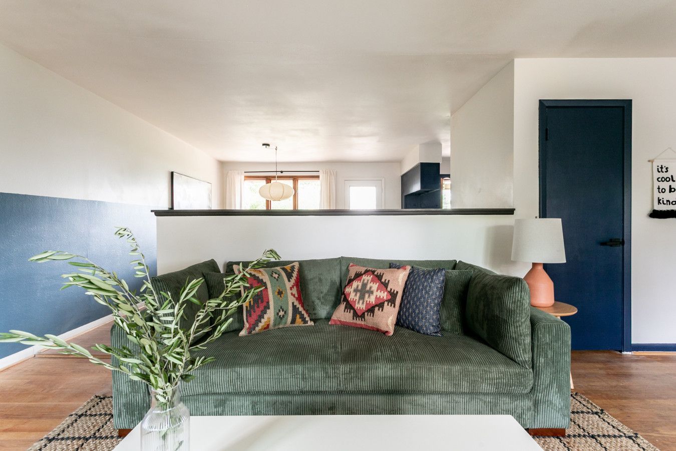 Living area with sky blue walls and green sofa