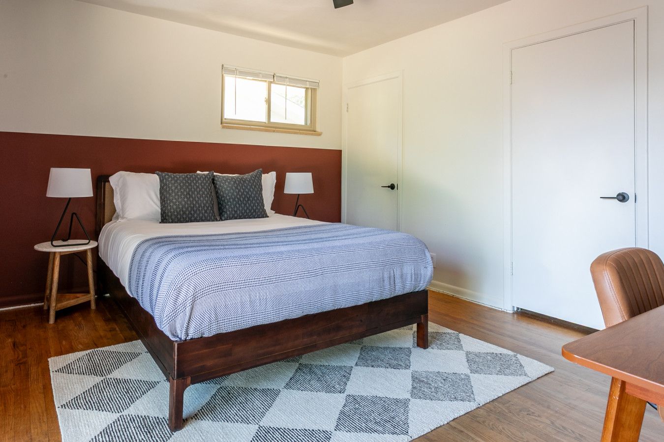 Bedroom with oxblood wall band and checked rug